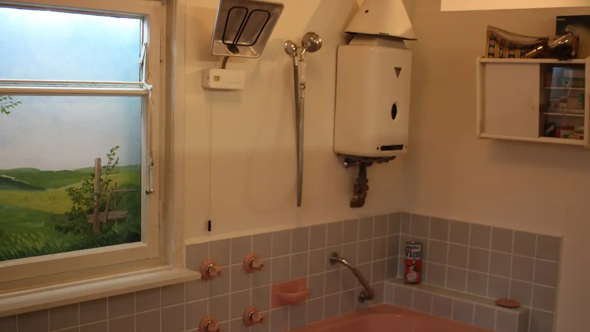 1960s bathroom with a gas water heater above the bathtub