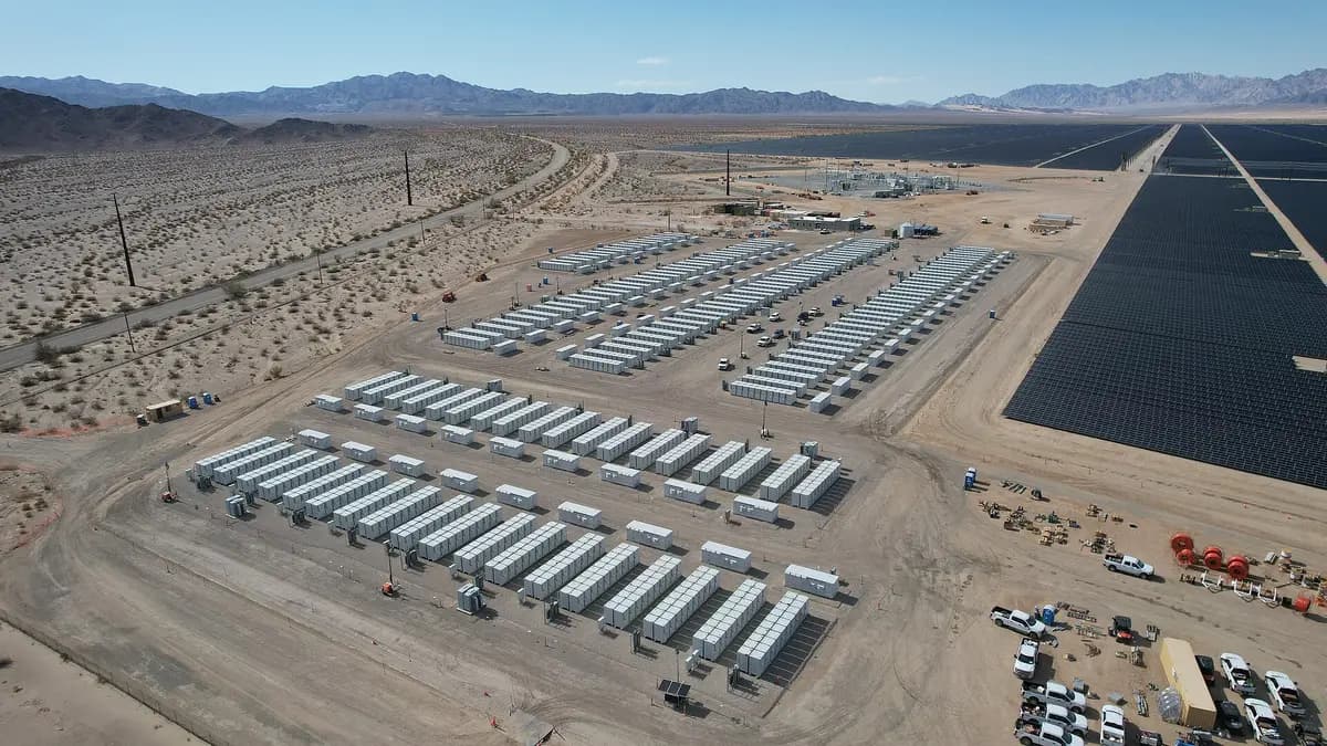 Vista aérea de um sistema de armazenamento com baterias em contêineres ao lado de uma usina solar no deserto