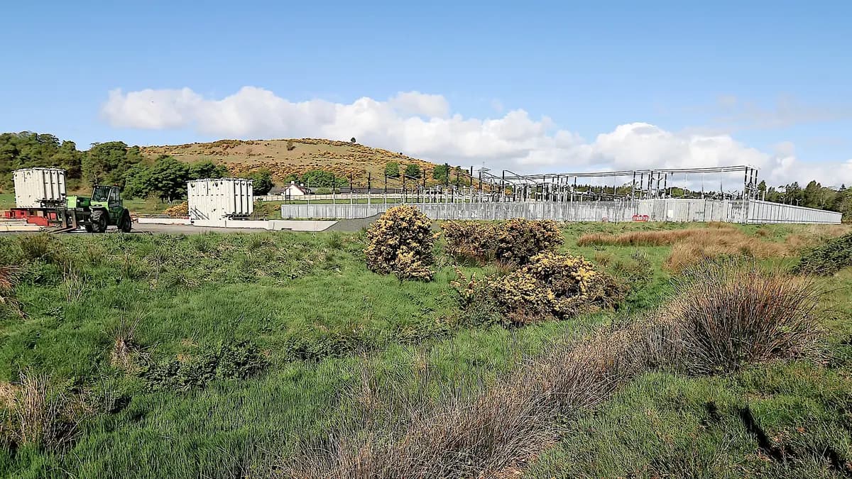Battery installation next to an electrical substation in a field
