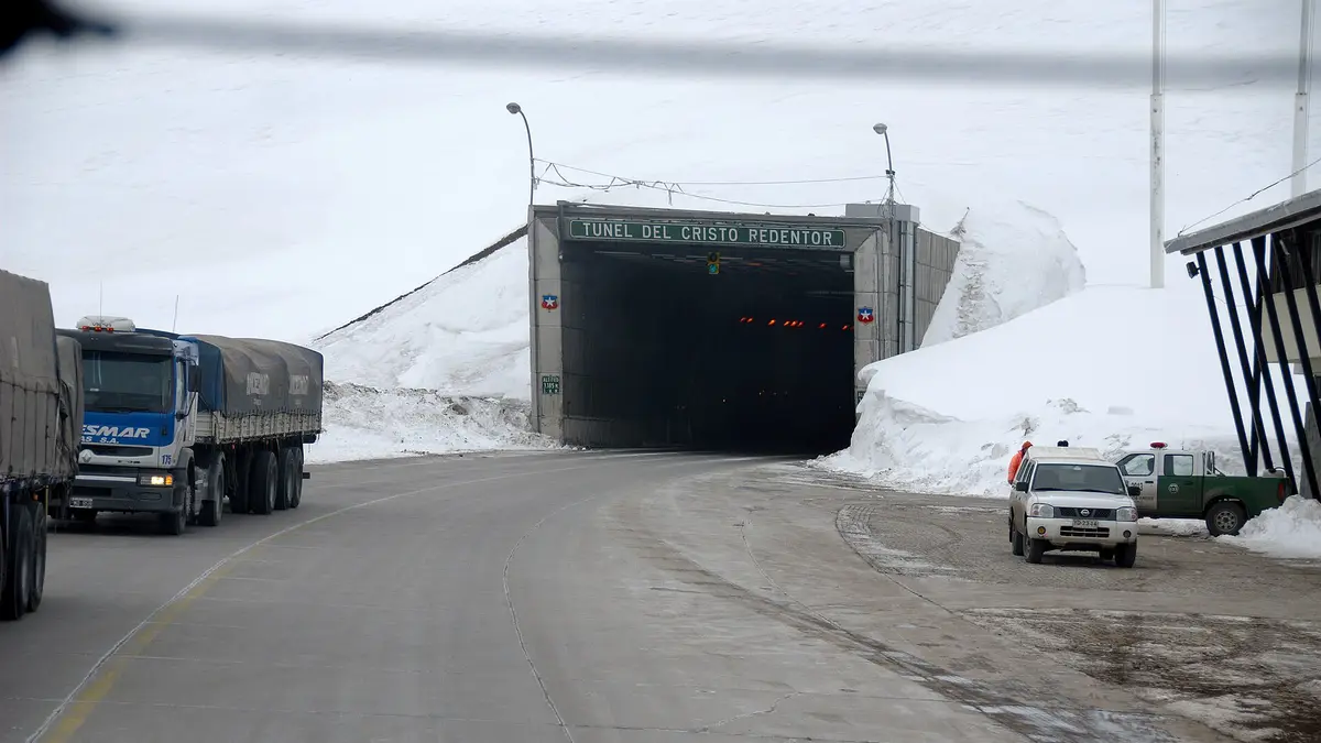 Camiones de carga detenidos en la entrada chilena del túnel Cristo Redentor, con nieve en los cerros