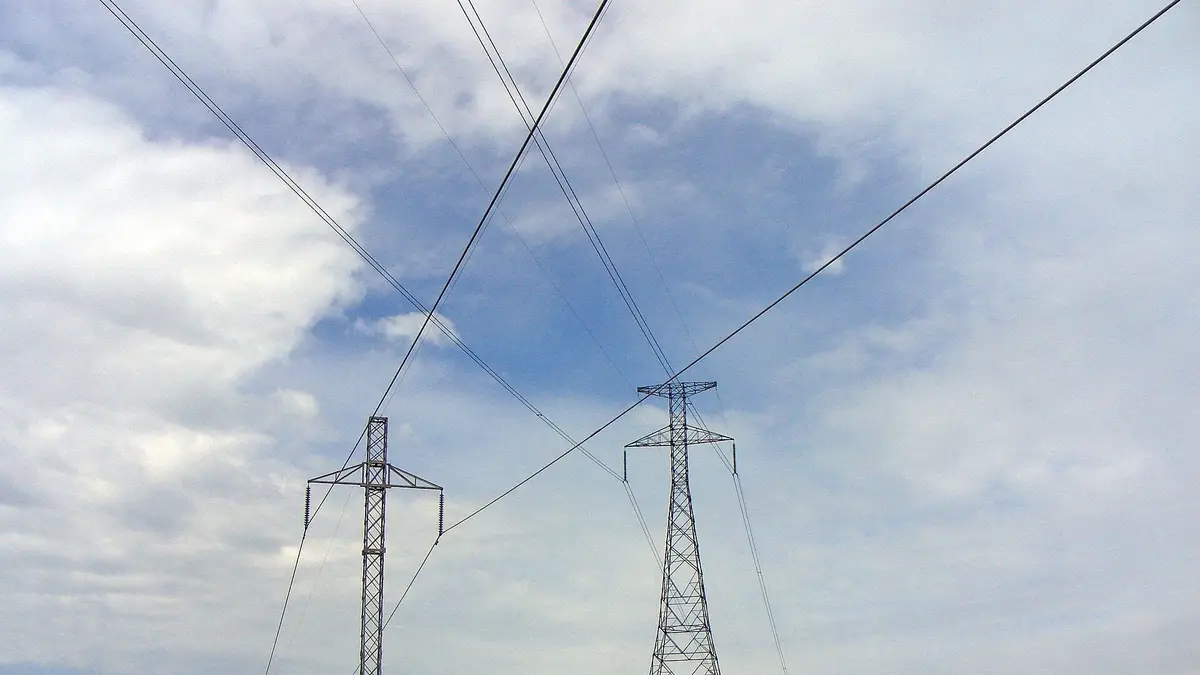 Cruce de dos líneas de transmisión de corriente continua con torres metálicas en una pradera de Dakota del Norte