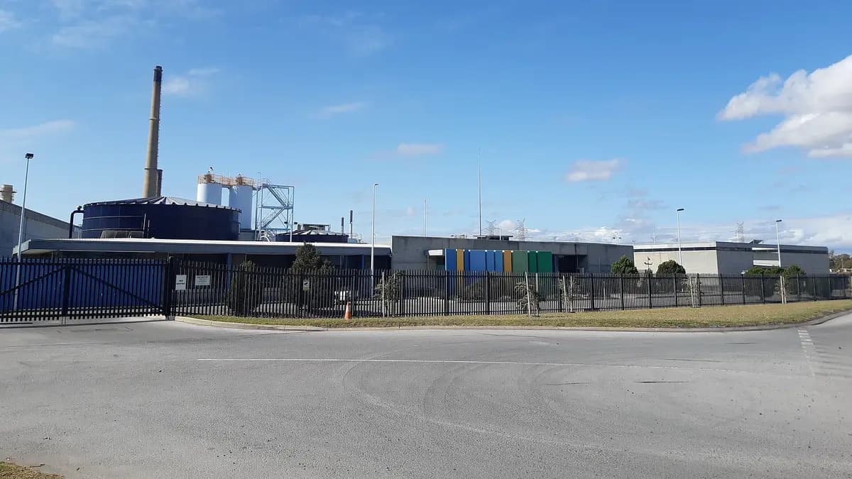 Buildings and chimney of the Perth seawater desalination plant in Australia under a blue sky
