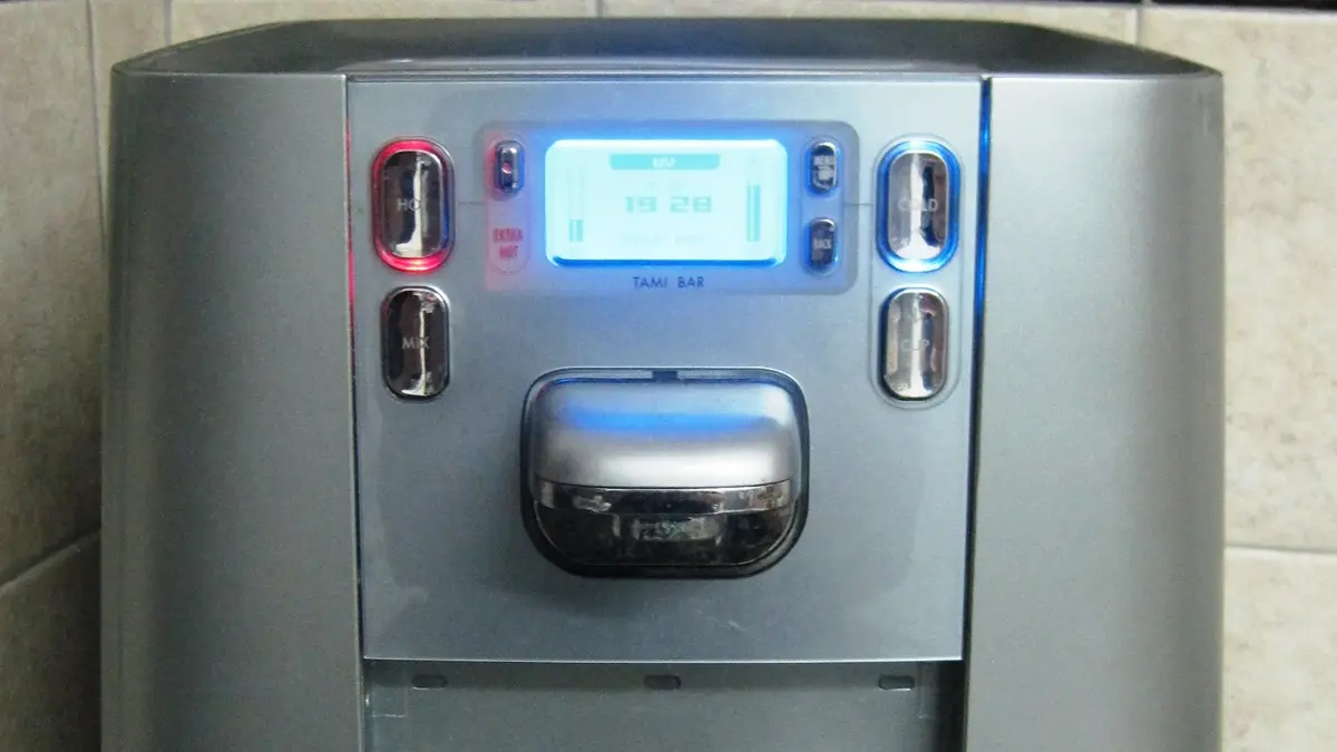 Painel frontal prateado de um bebedouro com visor digital e botões de água gelada e quente