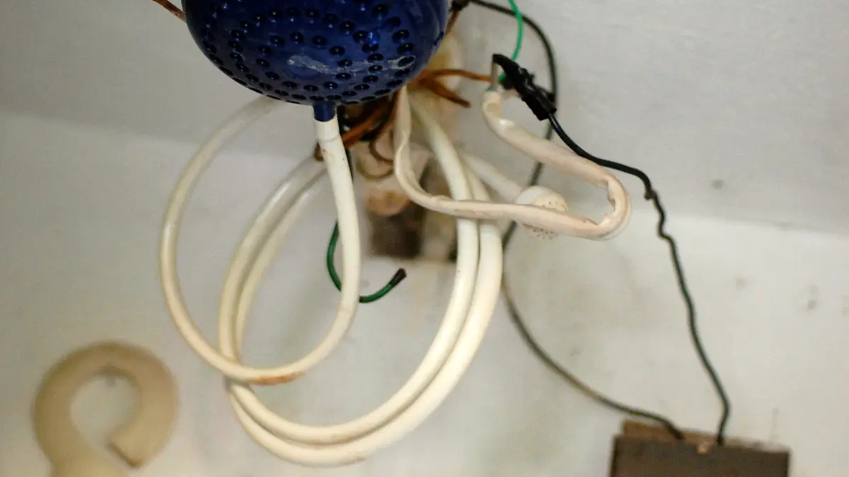 Chuveiro elétrico num banheiro da Guatemala com cabos expostos e emendas sem proteção