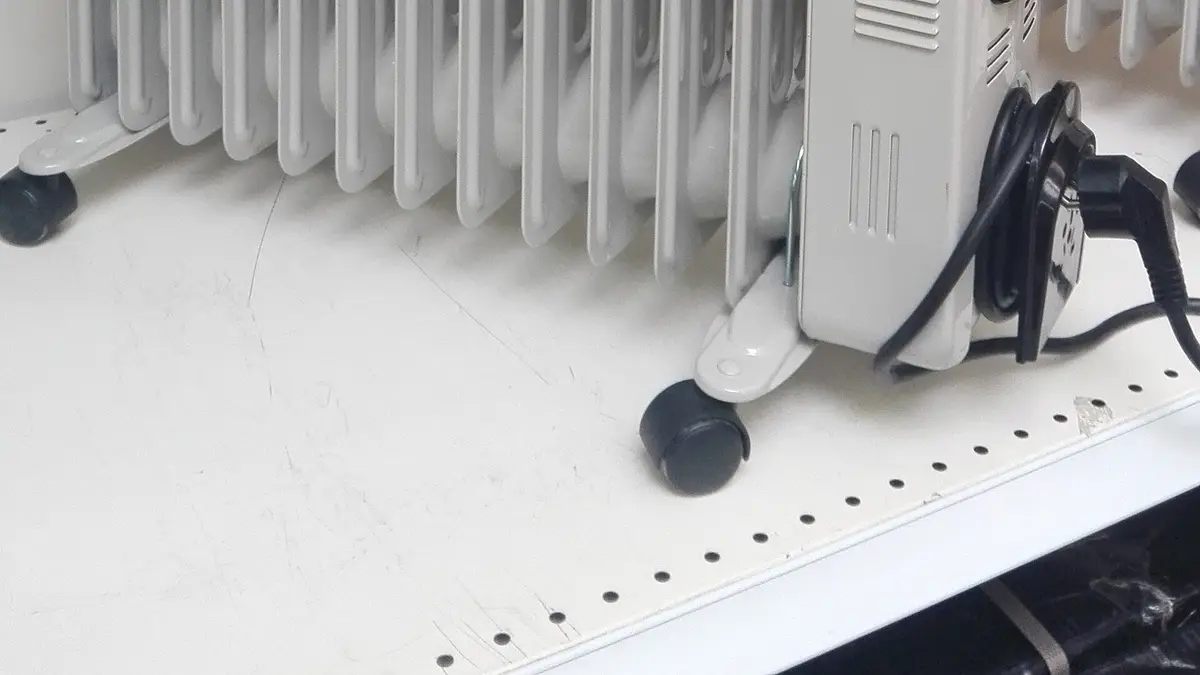 White oil-filled heater on wheels on the floor