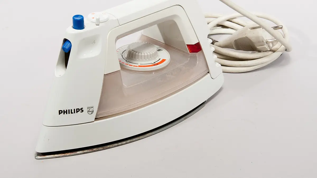 Ferro a vapor Philips branco com o cabo, sobre fundo branco