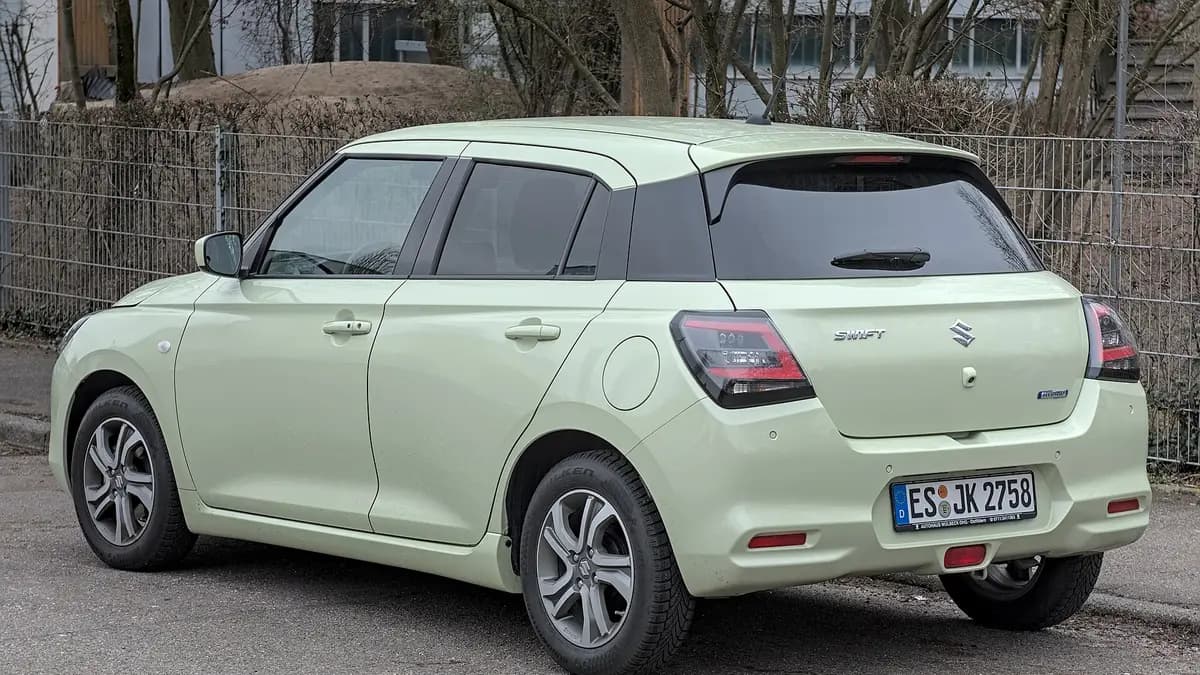 Suzuki Swift Hybrid verde-claro estacionado visto de trás