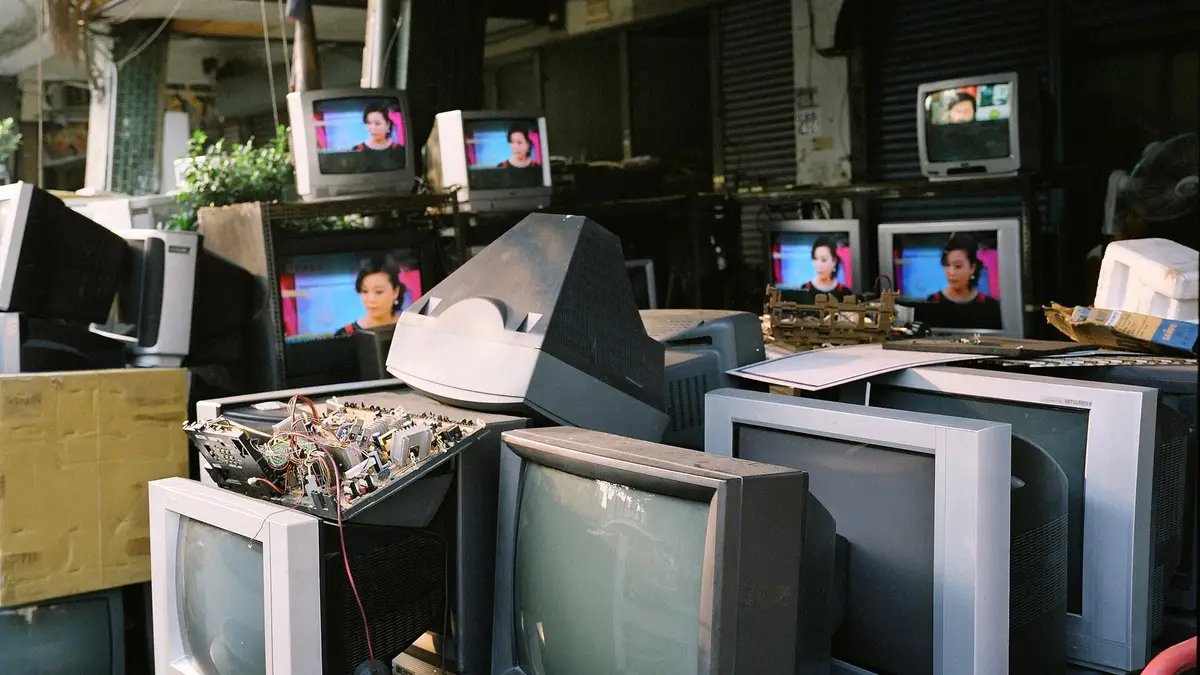 Televisores antigos de tubo empilhados em uma loja de eletrodomésticos