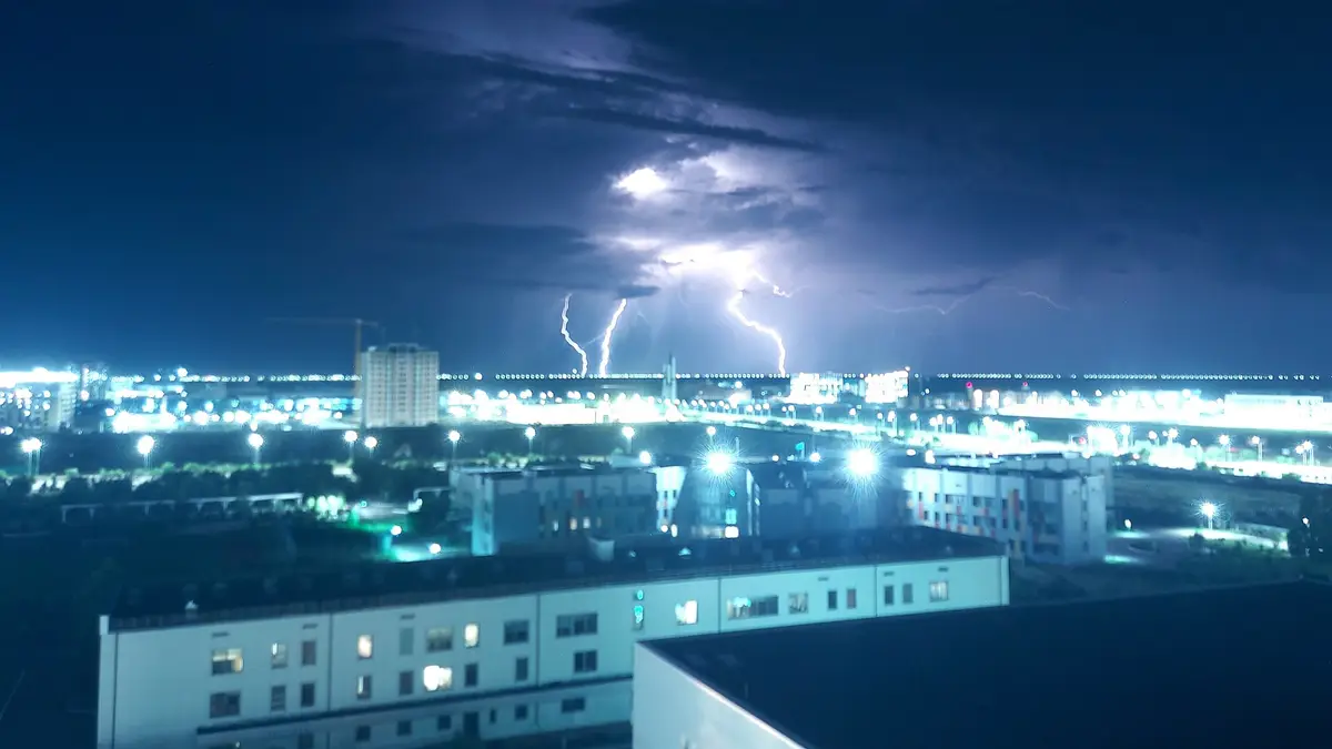Raios de uma tempestade elétrica sobre uma cidade à noite
