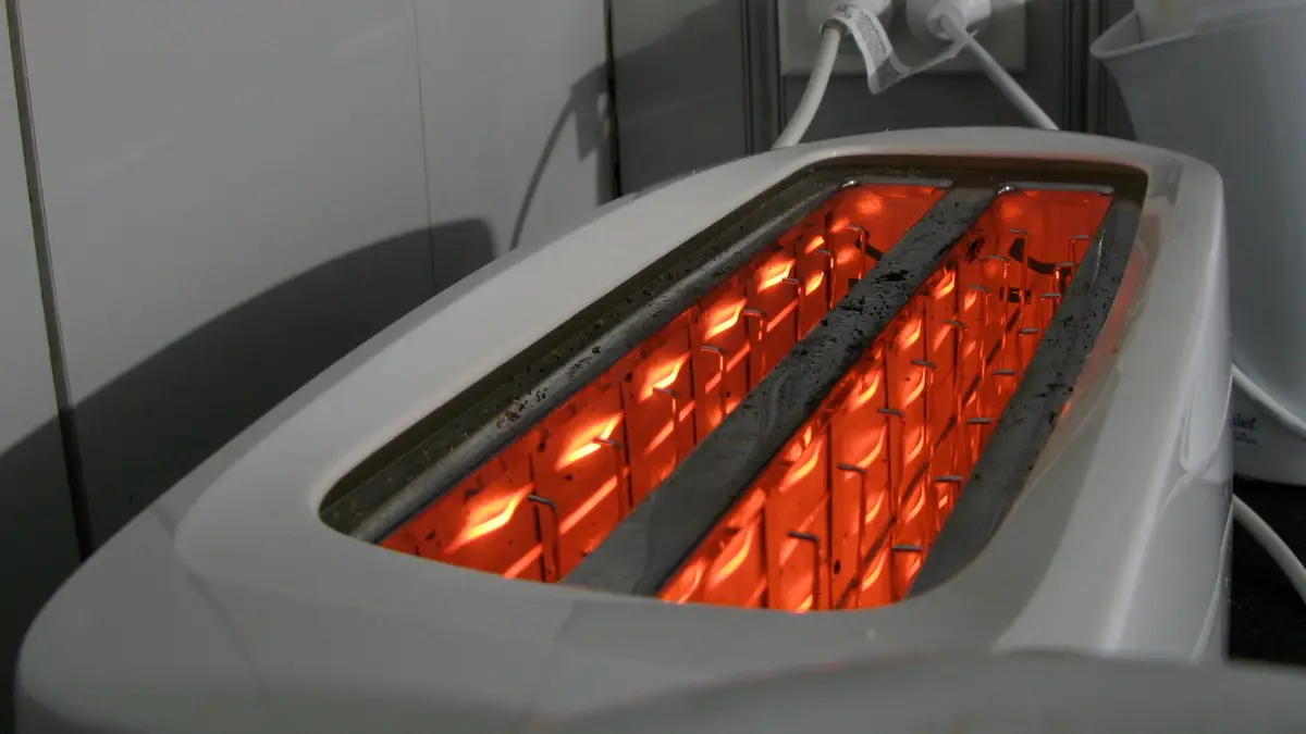 Resistencias al rojo dentro de las ranuras de una tostadora eléctrica blanca