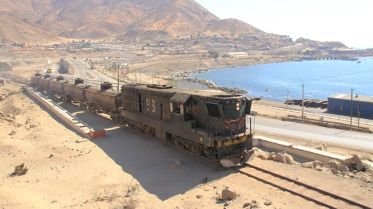 Um trem de carga com locomotiva preta inicia a viagem da baía de Chañaral rumo à fundição de Potrerillos
