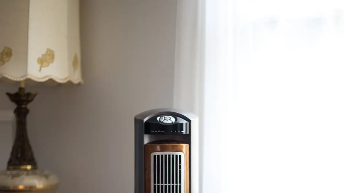 Tower fan next to a lamp in a room